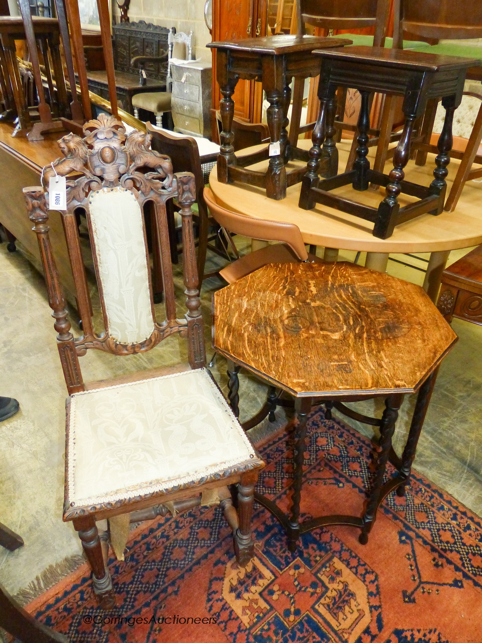 A 1920's octagonal oak centre table, width 60cm, height 64cm, together with a Flemish carved oak dining chair